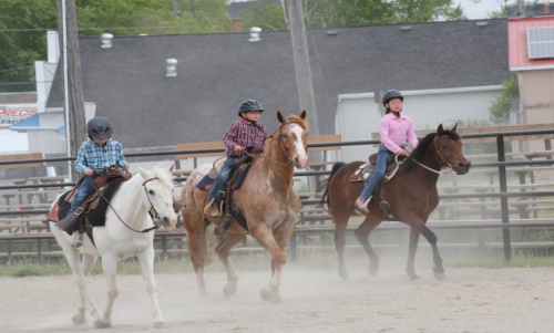 Three girls on horses in the riding ring